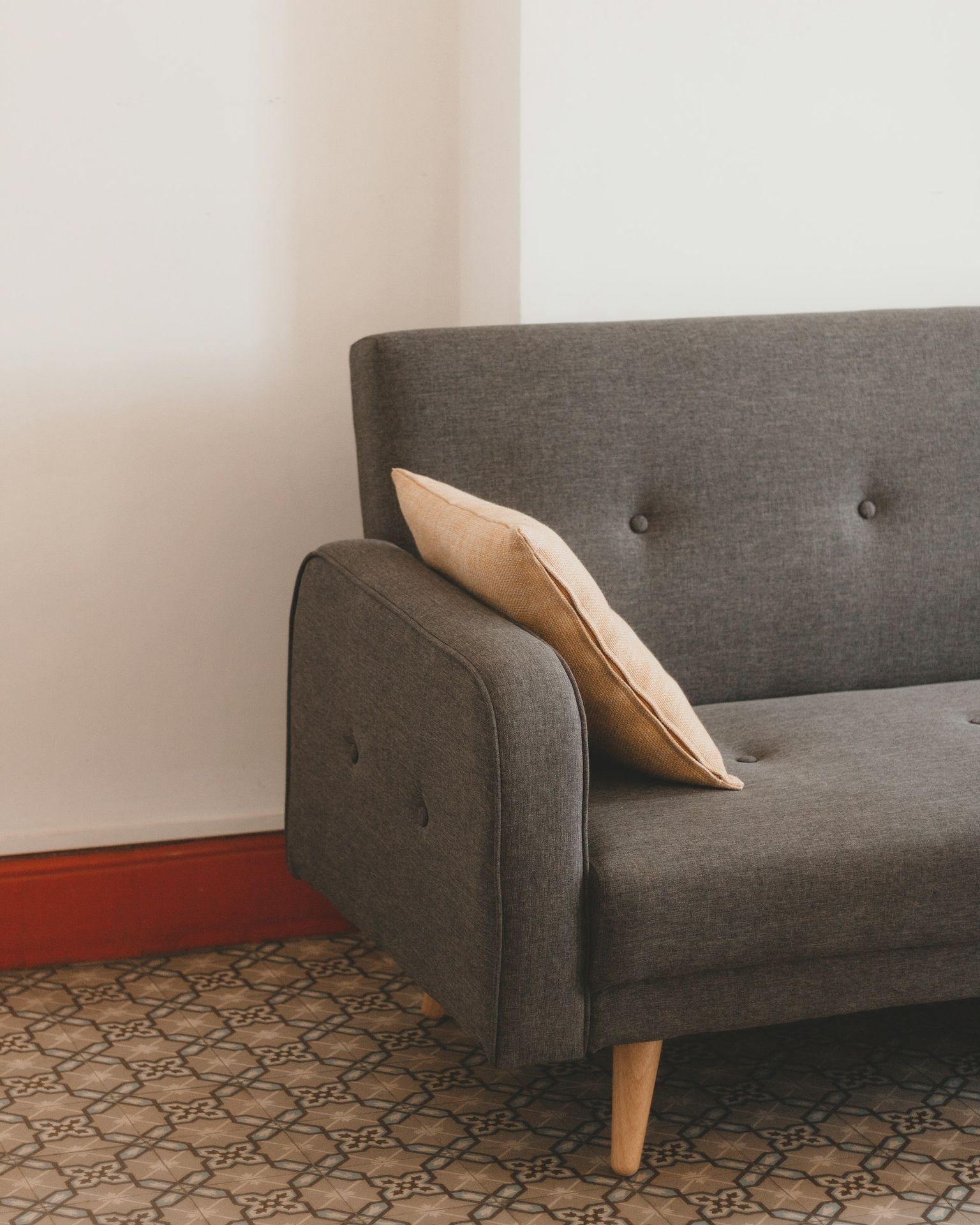 a gray couch with a pillow on top of it